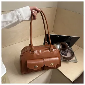 Detailed view of brown retro pillow bag featuring dual front pockets with gold twist locks