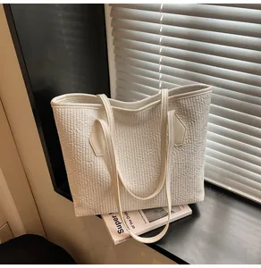 Gros plan du sac cabas gaufré blanc avec texture plissée géométrique et surpiqûres