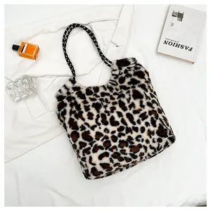 Close-up of leopard print faux fur tote bag with checkered handles on white fabric
