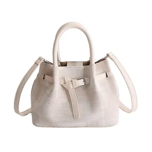 Minimalist canvas bucket bag with leather handles and adjustable shoulder strap for women