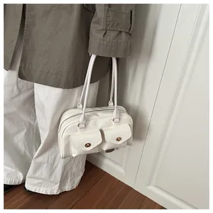 Close-up of white retro shoulder bag with double front flap pockets and slim handles