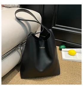 Gros plan du sac cabas en similicuir noir avec texte FASHION doré et texture lisse élégante