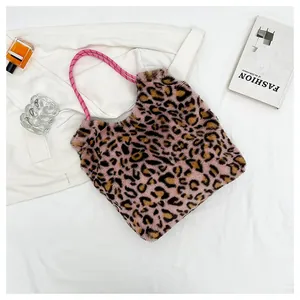 Flat lay of pink leopard print plush tote bag with woven rope handles and fashion props