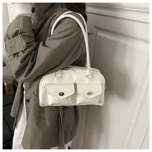Close-up of a white vintage shoulder bag with dual front pockets and gold twist locks