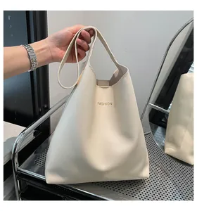 Détail d'un sac à main blanc en cuir avec lettrage doré fashion et reflet de miroir