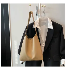 Détail du sac cabas en cuir kaki avec texte embossé et une longue bandoulière fixe