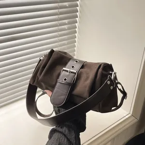 Sac bandoulière vintage en daim marron foncé avec grande boucle argentée et texture plissée