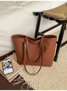 Détail du sac cabas marron avec gaufrage à rayures verticales et longues anses