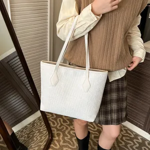 Grand sac cabas blanc à rayures texturées porté par un mannequin dans un style décontracté