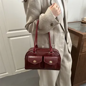 Vintage burgundy pillow bag with double front pockets and gold metallic buckles