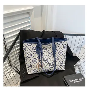 Détail du grand sac cabas à carreaux bleus et blancs avec pendentif en métal doré