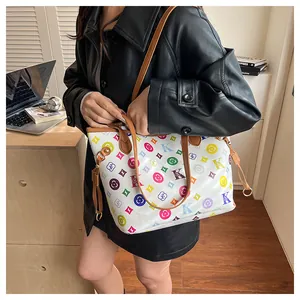Close-up of vintage tote bag with colorful monogram print and brown leather handles