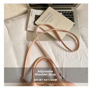 Λεπτομέρεια από ρυθμιζόμενο λουράκι και υφή δέρματος σε ροζ τσάντα πουγκί