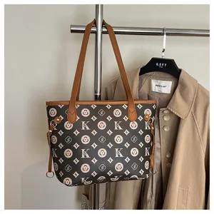 Detail of dark brown tote bag featuring vintage pattern and contrast handle on a coat rack