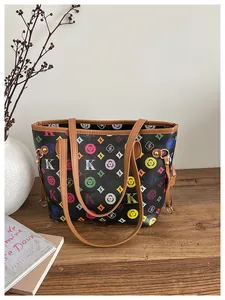 Close-up of black tote bag featuring colorful geometric floral patterns and brown leather handles