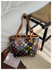Detail of retro monogram tote bag with colorful letters and brown leather handles