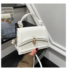 Detail of white mini square bag with golden twist lock and knotted handle