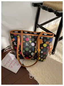 Detail of colorful geometric K/S monogram print on a black faux leather tote bag
