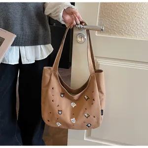 Close-up of animal embroidery and logo detail on a brown canvas tote bag
