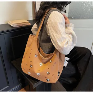 Close-up of cute animal embroidery on brown canvas tote bag with side brand label