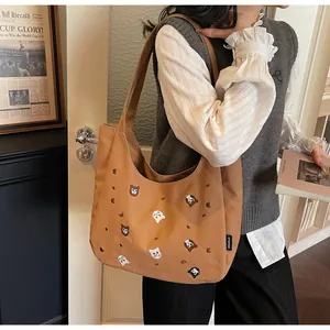 Detailed view of caramel canvas tote bag with cute animal embroidery and branded label