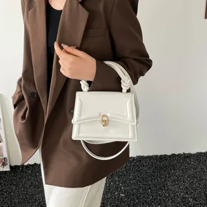 White leather square handbag with golden horseshoe buckle and braided knot handle