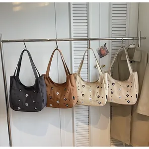 Detail showing four colors of embroidered canvas tote bags with cute animal patterns
