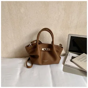 Detail of brown litchi pattern leather bucket bag with silver hardware and dual handles