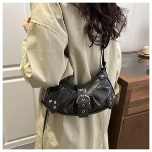 Close-up of a Y2K black biker bag with pleated leather and silver buckle detail