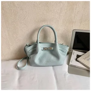 Detail of light blue leather bucket bag with silver metal buckle and elegant top handle