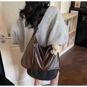 Vue arrière détaillée d'un grand sac hobo en similicuir marron avec breloque agneau