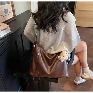 Détail du sac cabas marron avec bandoulière réglable et breloque ours peluche