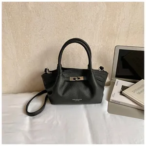 Detail of black lychee grain leather bucket bag with silver twist lock and strap