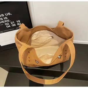 Detailed view of canvas tote interior with zipper pocket and bear embroidery