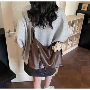 Détail du sac à bandoulière en PU marron foncé avec pendentif alpaga en peluche doux