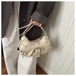 Detail view of beige Y2K biker shoulder bag featuring silver rivets and metal buckle