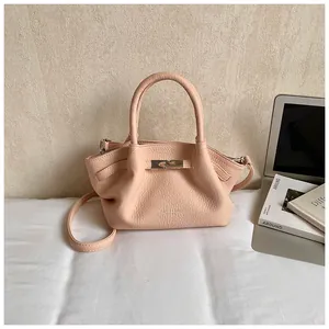 Detail of light pink lychee texture leather bucket bag with silver metal clasp hardware