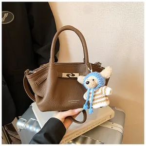 Brown lychee leather bucket bag with silver twist lock and cute teddy bear charm detail