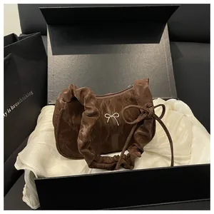Sac croissant marron plissé avec nœud argenté présenté dans un coffret cadeau