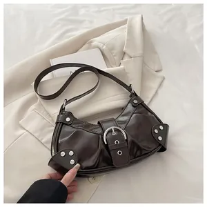 Close-up of vintage dark brown biker bag with silver rivets and shiny leather texture