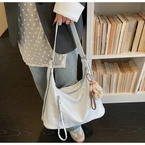 Vue détaillée du sac hobo bleu clair montrant les poches zippées et le similicuir texturé