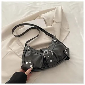 Detailed macro view of black crescent bag with silver rivet studs and matte finish