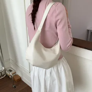 Detailed view of the off-white crescent hobo bag worn on the shoulder by a model