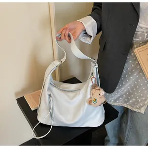 Détail du sac hobo bleu clair avec fermeture éclair et breloque agneau en peluche