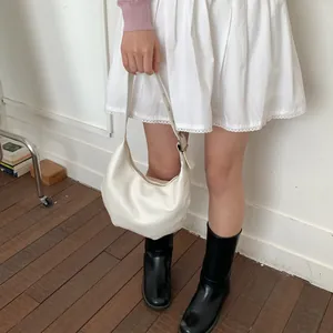 Detail of adjustable strap and silver buckle on off-white crescent shoulder bag