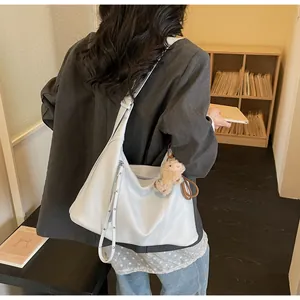 Détail du sac hobo en cuir blanc avec zips argentés et charmant mouton en peluche