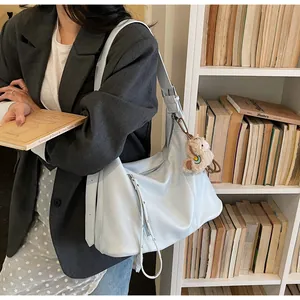 Sac hobo bleu clair minimaliste porté épaule avec accessoire de pendentif ours en peluche