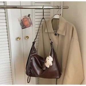 Détail du sac fourre-tout en similicuir marron avec pendentif en laine d'agneau