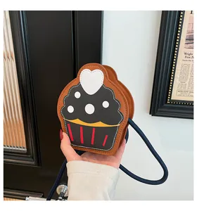 Detailed view of a cupcake-shaped crossbody bag featuring heart decor and blue rope strap