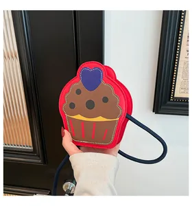 Detail of red cupcake-shaped crossbody bag with heart embroidery and blue strap